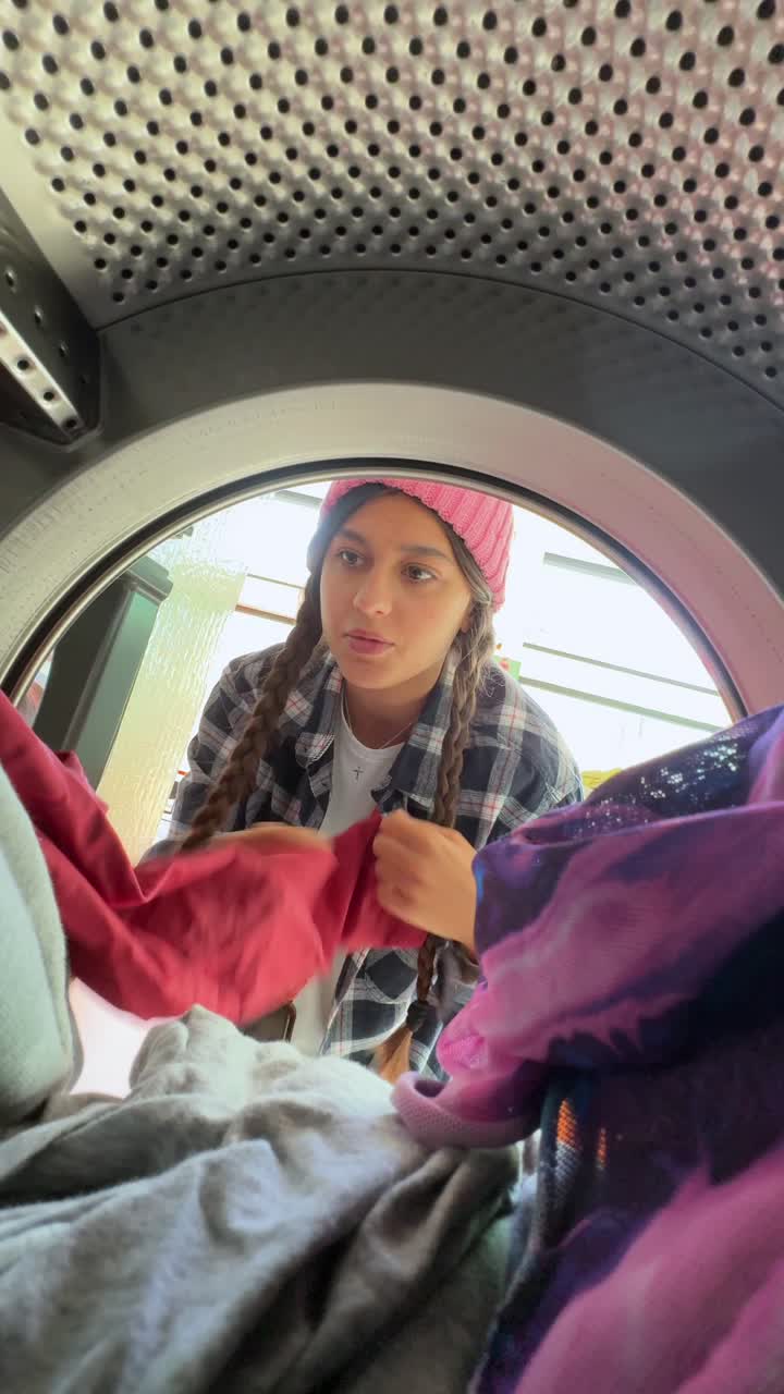 Teenage Girl Loading Clothes into Washing Machine