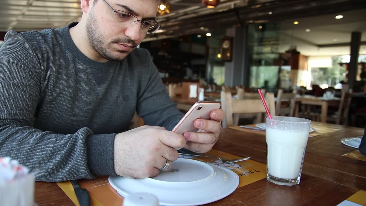 Hombre usando un teléfono móvil en el restaurante