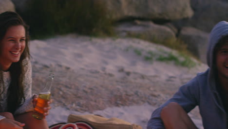 friends enjoying a campfire on the beach at sunset