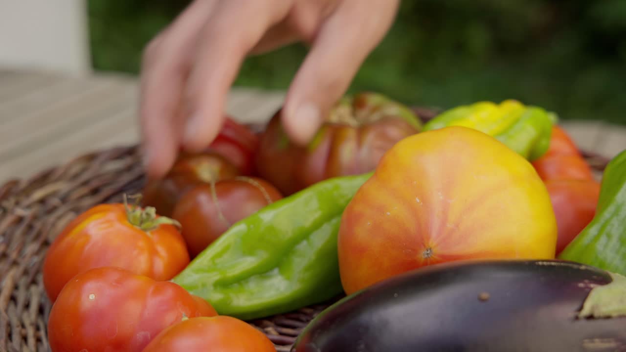 One person selects fresh organic vegetables from a wicker basket