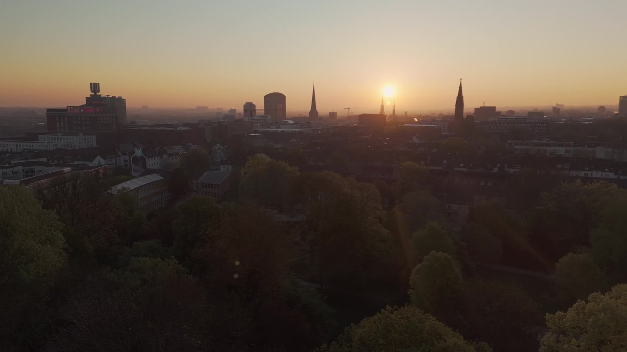 Luftfoto av Dortmund, Tyskland, med solen som står opp bak byens kirketårn