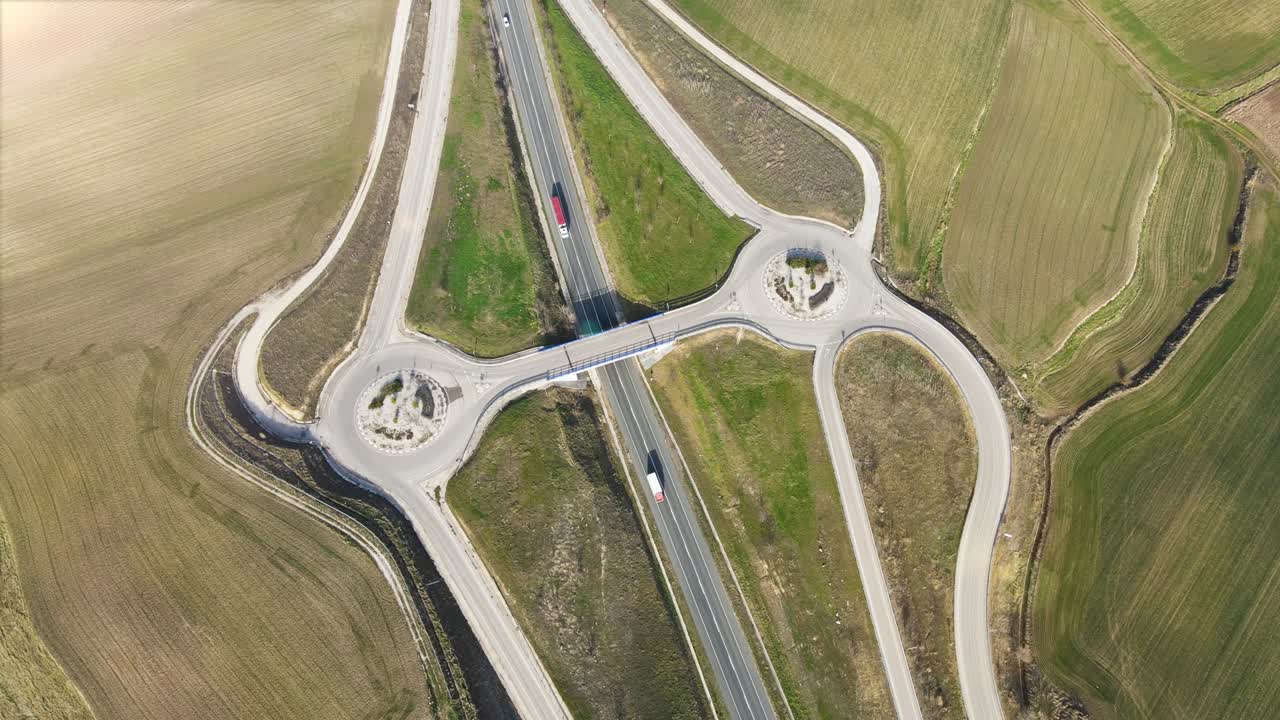 vista aérea de drones sobre una intersección de cruce de carreteras de campo. tráfico en el paso aéreo en un paisaje rural. imágenes de alta calidad 4k