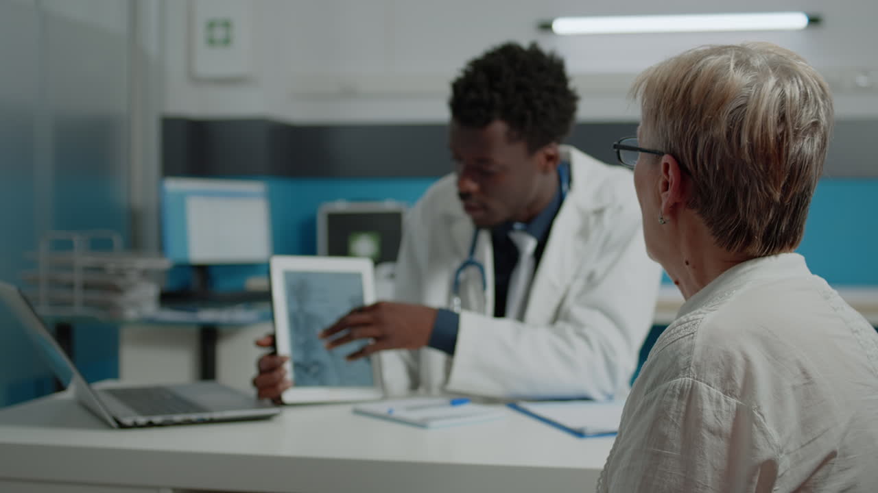 Doctor holding tablet explaining bones fracture recovery