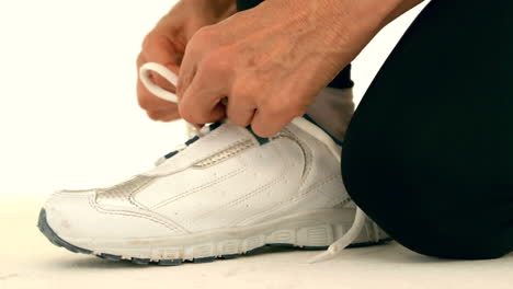 corredora atando los cordones de sus zapatos