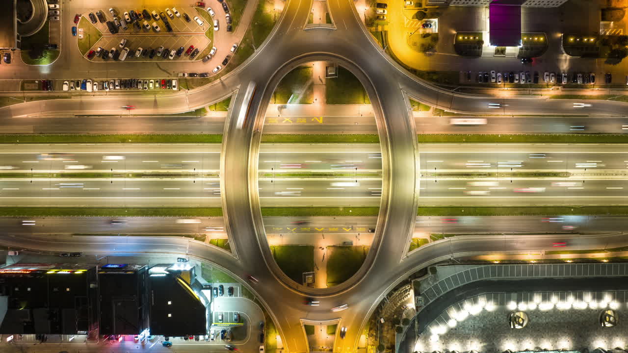Aerial Night View of a Highway Interchange and Roundabout with Traffic Light Trails