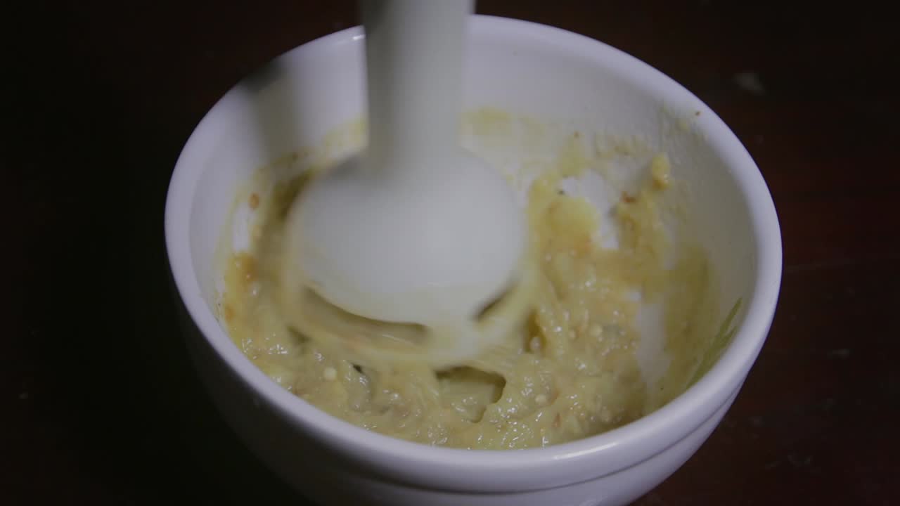 berenjena procesada para puro en una taza con una batidora de mano