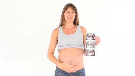 pregnant woman holding a scan of her baby