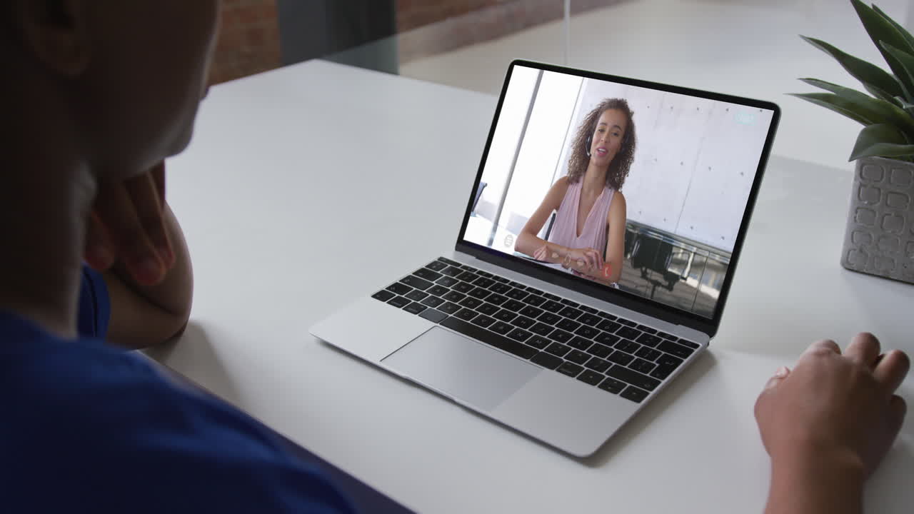 Mid section of african american woman having a video call with female colleague on laptop at office