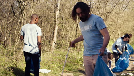 hombre activista usando pinzas para agarrar basura y desechos plásticos