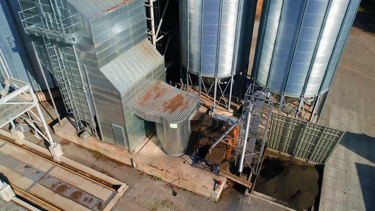 Grain warehouse, granary. Large steel towers for storing crops. Large animal feed factory. Aerial view.
