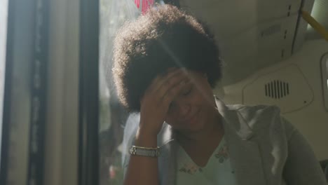 Thoughtful-plus-size-biracial-woman-sitting-in-bus