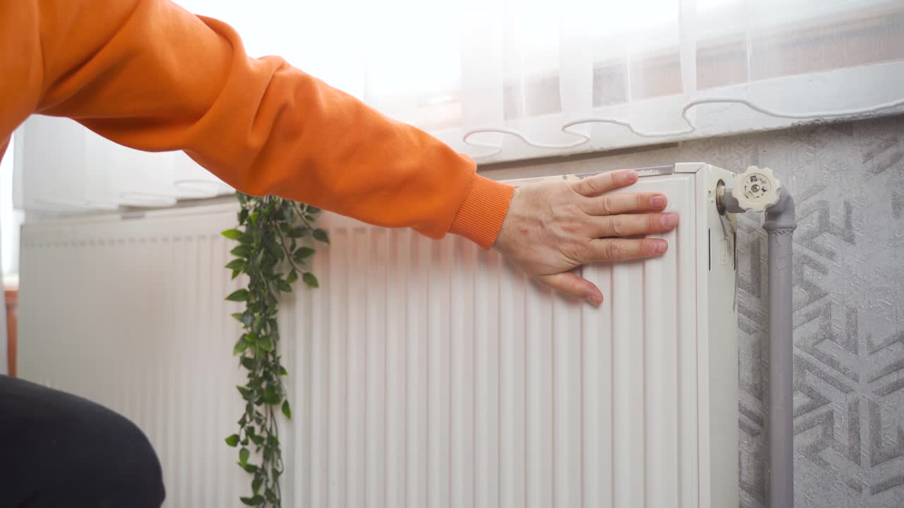 el hombre frío abre la válvula de la caldera combinada en casa.