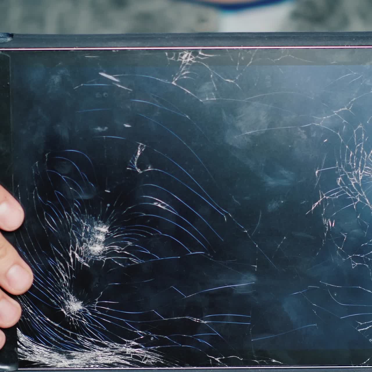 A Man Holds A Tablet With A Broken Screen