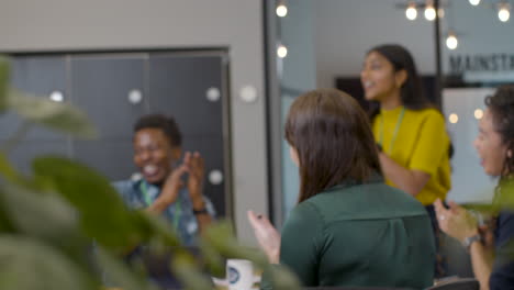 colleagues in meeting start to celebrate and clap hands