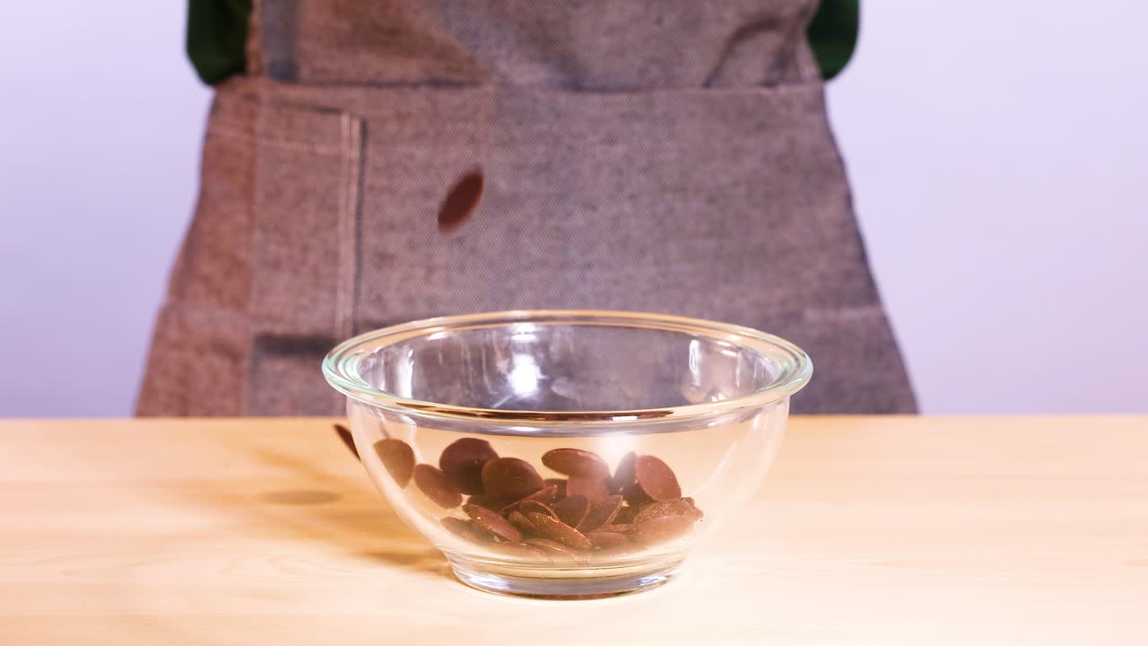 discos de chocolate cayendo en un cuenco de vidrio