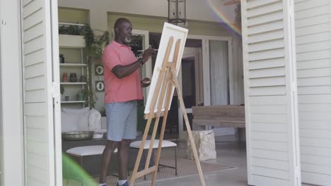 happy senior african american man painting in slow motion