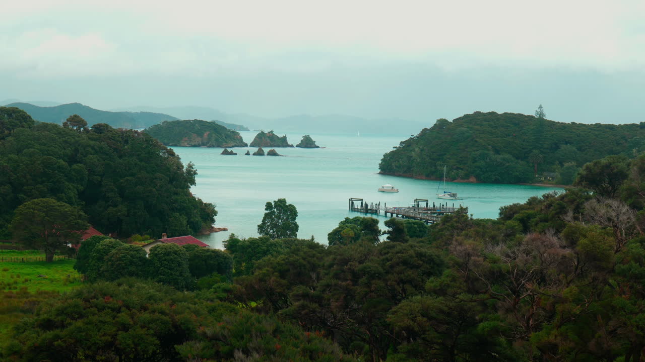 toma amplia en cámara lenta del muelle con islas en el fondo en la isla de urupukapuka, nueva zelanda