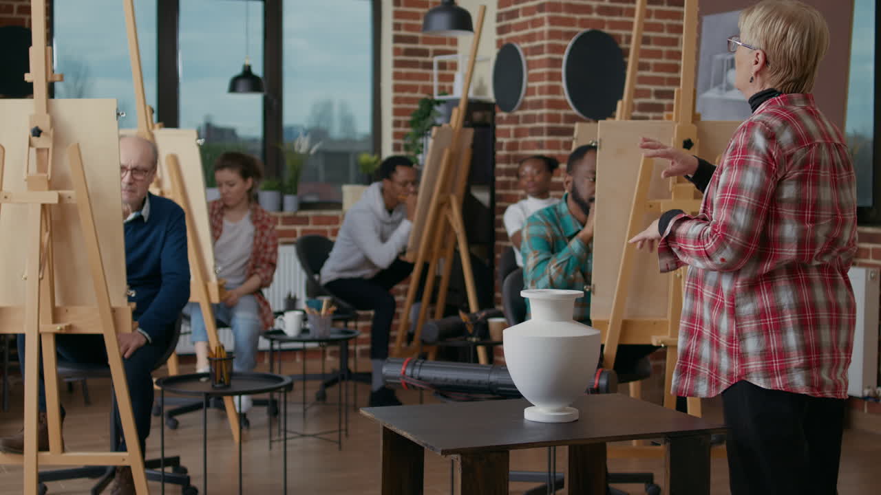 Senior teacher explaining drawing technique to diverse team of students