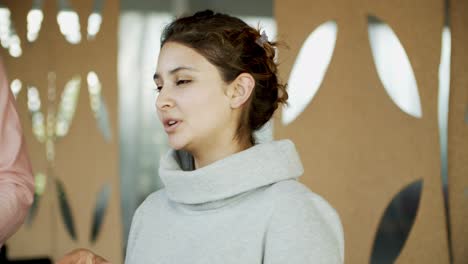 Smiling-young-woman-talking-to-colleagues