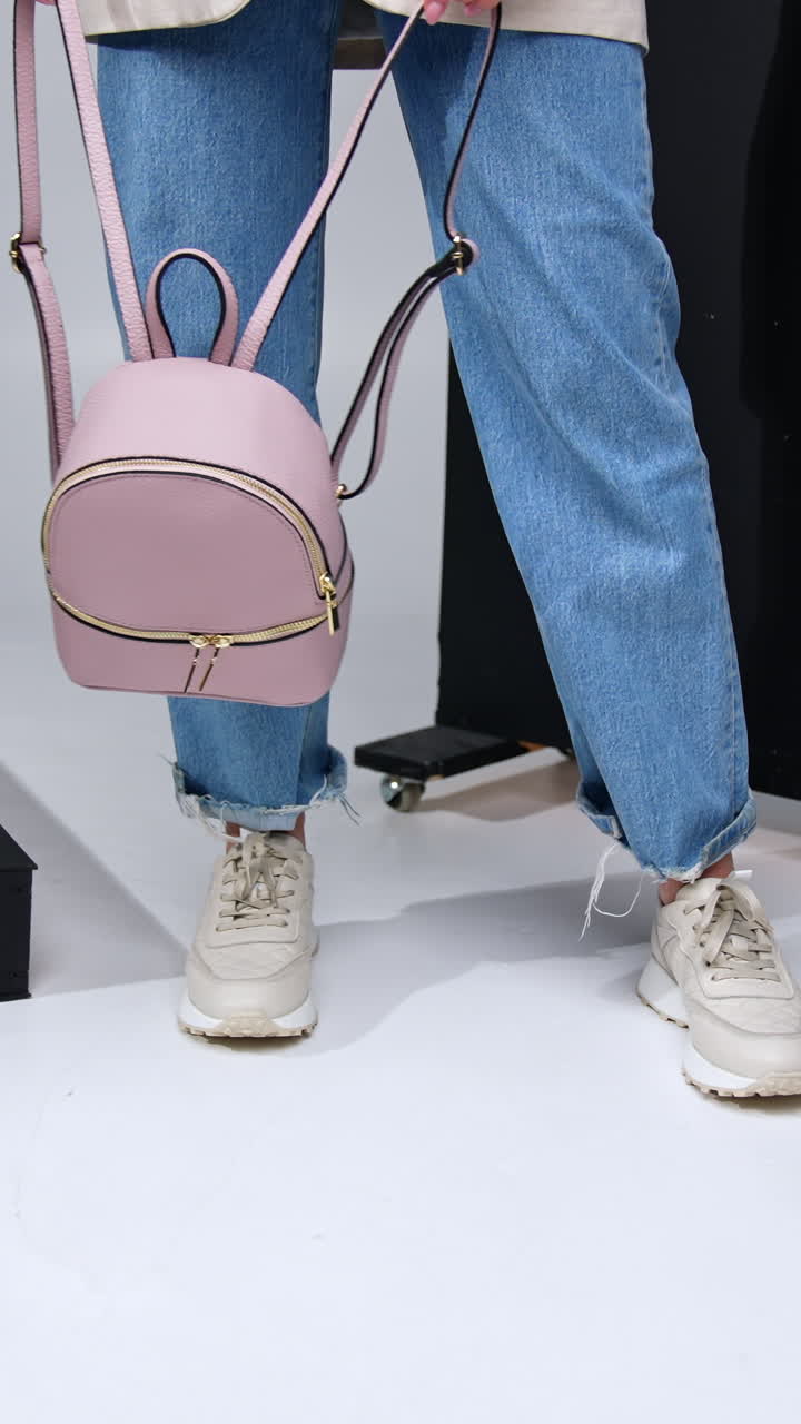 Woman wearing jeans, sneakers, and a pink backpack