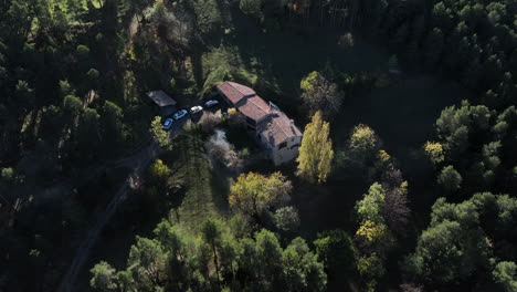 aerial view orbiting saldes rural village home surrounded by green woodland trees near pedraforca, catalonia