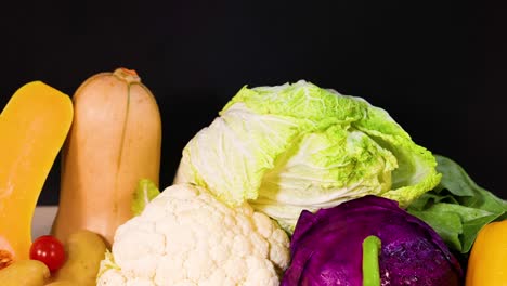 assorted vegetables displayed against a black backdrop