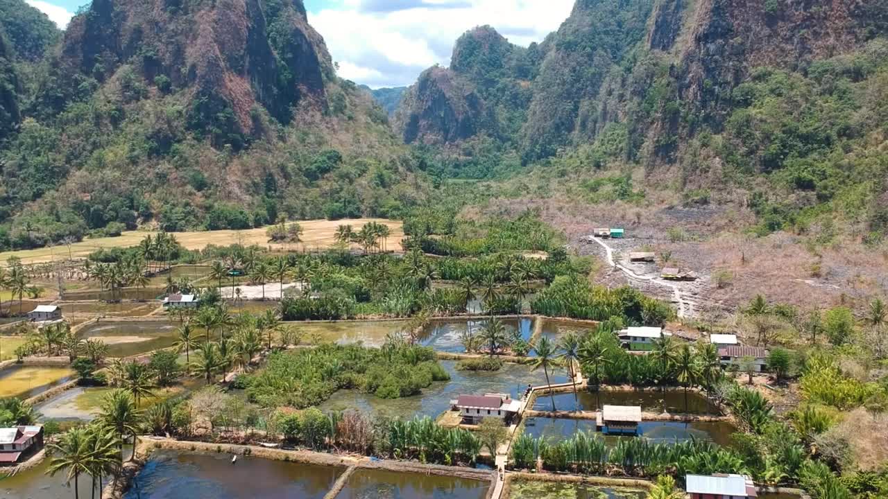 aerial de la hermosa joya oculta rammang rammang pueblo con gigantescos acantilados de piedra caliza, cabañas auténticas y enormes montañas cársticas en sulawesi, indonesia