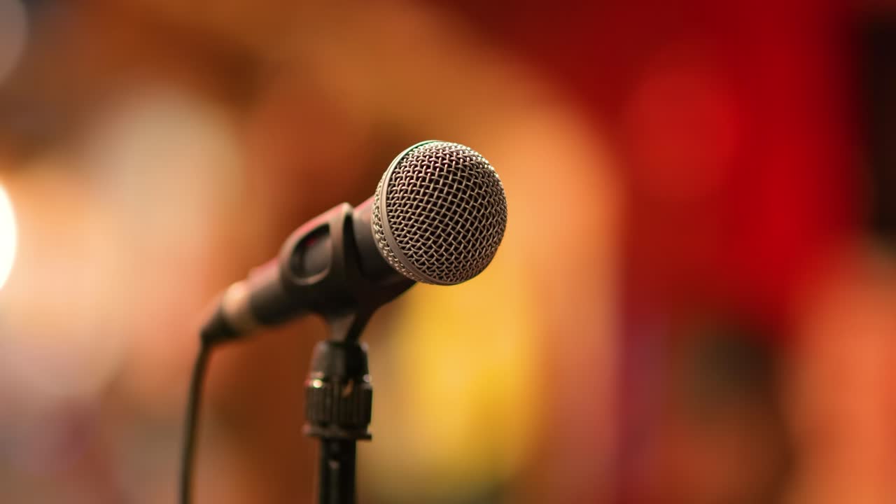micrófono en el escenario contra un fondo de auditorio.