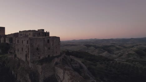 Drone-Volando-En-Movimiento-Circular-Alrededor-De-Las-Ruinas-De-Craco-En-El-Sur-De-Italia-En-El-Amanecer-Muy-Temprano-En-La-Mañana-En-4k