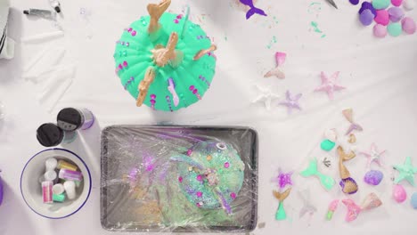 decorating art pumpkins with rhynestones, mermaid tails, and seashells in mermaid theme