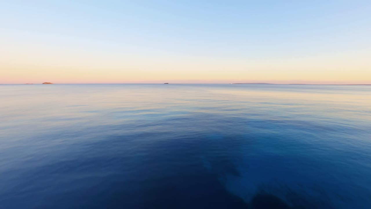 바다를 가로질러 빠르게 날아가는 fpv 공중은 석양에 이비자의 경치 좋은 해안을 따라 점재하는 리조트를 드러냅니다.