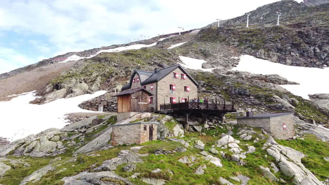 casa rodeada de piedras y algunos campos de nieve con una cuerda en el fondo en los alpes en kaernten, austria