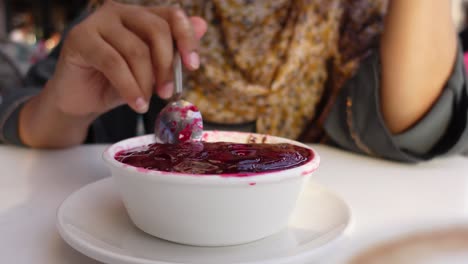 una mujer comiendo un postre.