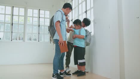 young asian students slapping little boy demonstrating disrespect, cruelty. bullying, discrimination and racism concept