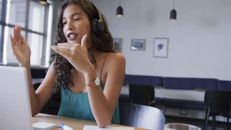 Biracial-Gelegenheitsgeschäftsfrau,-Die-Videoanrufe-Mit-Laptop-Am-Schreibtisch-Macht,-Zeitlupe