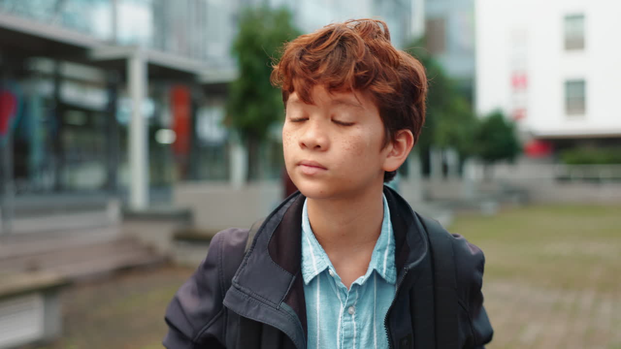 Boy with backpack outside of school