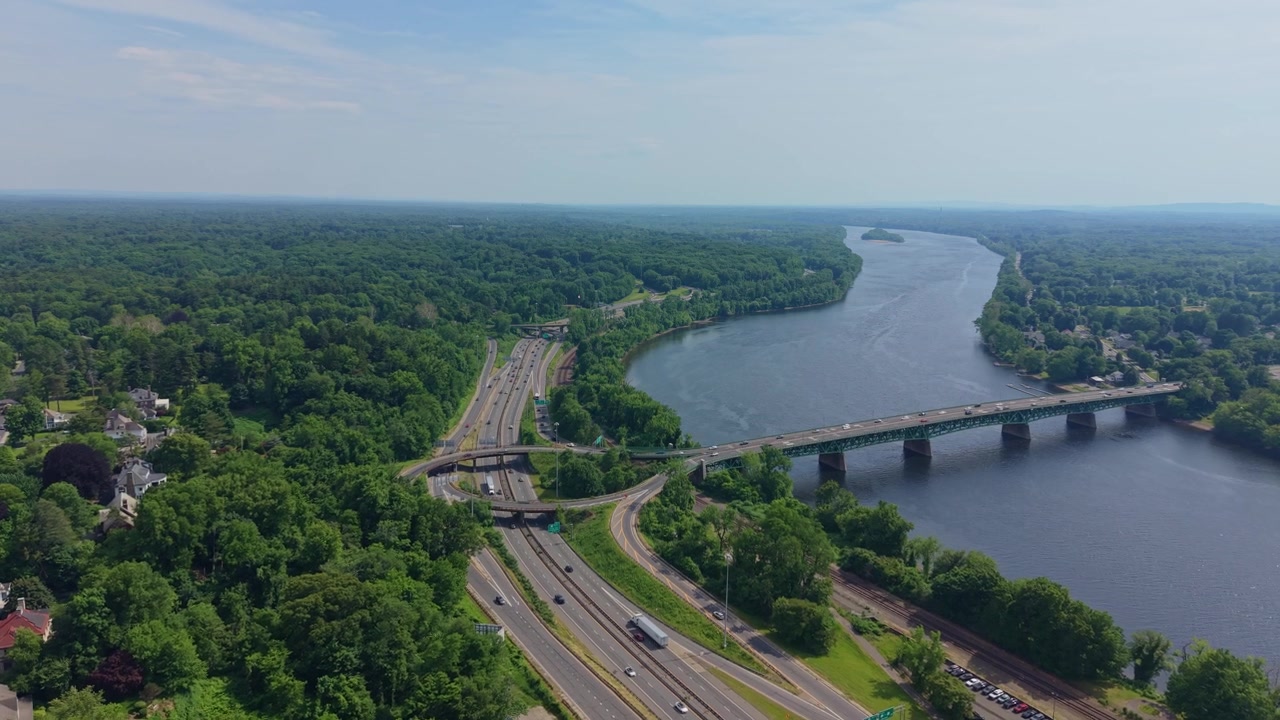 ABD, Massachusetts, Springfield'da, ormanlık bir manzara içinden geçen Julia B. Buxton Köprüsü ve ulaşım koridoru üzerinden Connecticut Nehri'ne doğru yaklaşan havadan çekim.