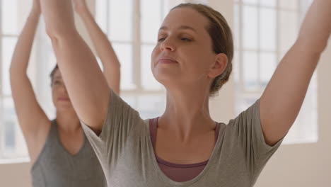 portrait happy pregnant caucasian woman in yoga class practicing warrior pose meditation enjoying group physical health exercise