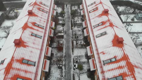 antena de techos de ladrillo rojo contrastantes cubiertos de nieve, en calles grises nevadas