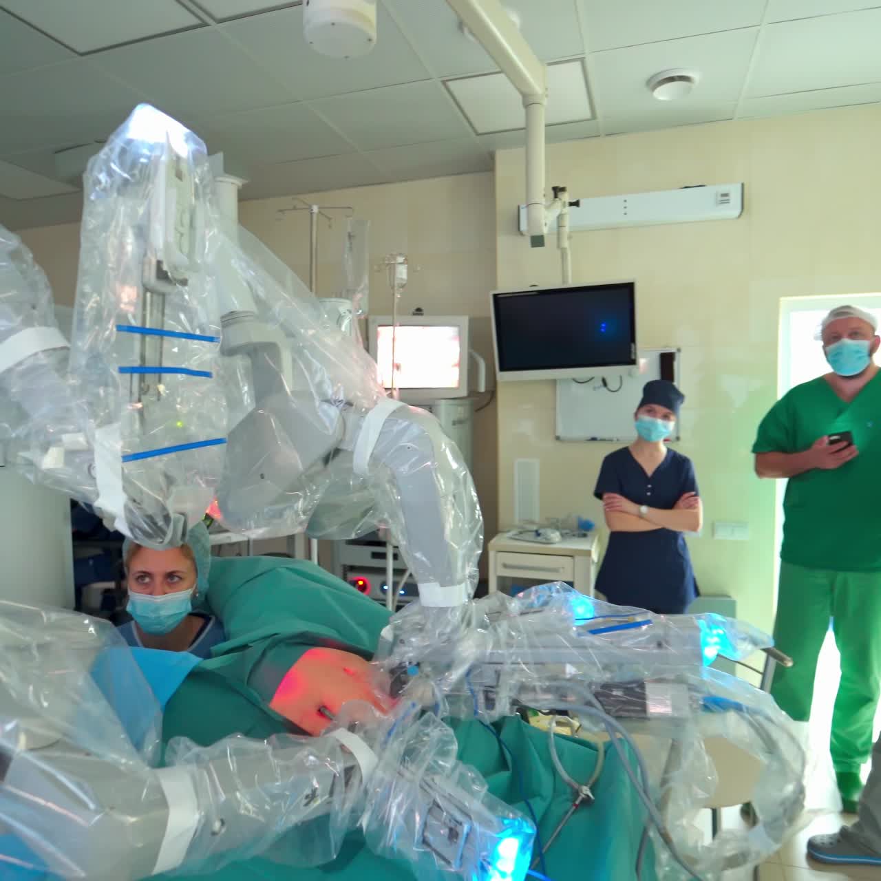 Machine arm surgeon in futuristic room. Team of surgeons during surgery via minimally invasive robotic surgery