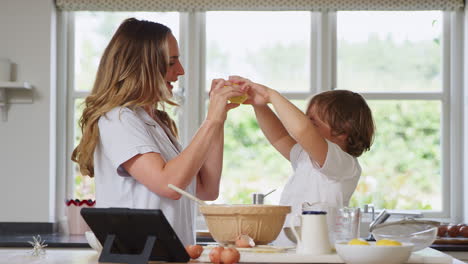 Madre-E-Hijo-En-Pijama-Haciendo-Muecas-Con-Limones-Mientras-Hornean-Juntos-En-La-Cocina-De-Casa