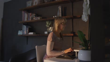 woman using computer at home at night