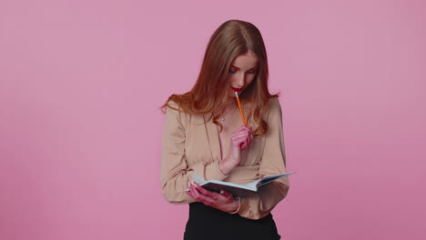 Pensive-businesswoman-making-notes-writing-down-thoughts-with-pen-into-notepad-notebook-diary-indoor