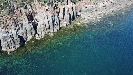 drone aerial over tropical blue water and beach pan up