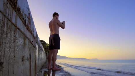 Hombre-Sin-Camisa-Toma-Fotos-Con-El-Teléfono-En-La-Playa-De-Bang-Niang,-Khao-Lak,-Tailandia