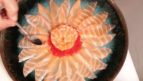 vista superior del sashimi de salmón en forma de flor con caviar rojo dispuesto en un plato - toma de ángulo alto