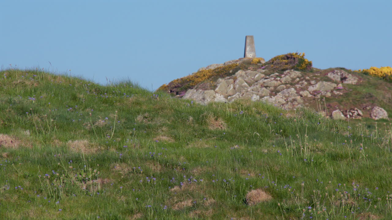 Looking across Hafan y Môr to a stone path marker