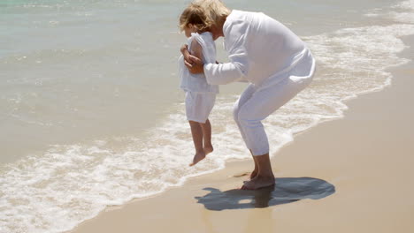 la abuela y la niña se divierten en la playa