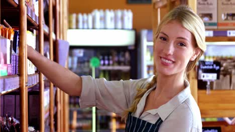 female staff arranging a grocery product on shelf