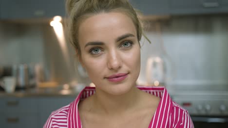 Cheerful-young-woman-in-kitchen